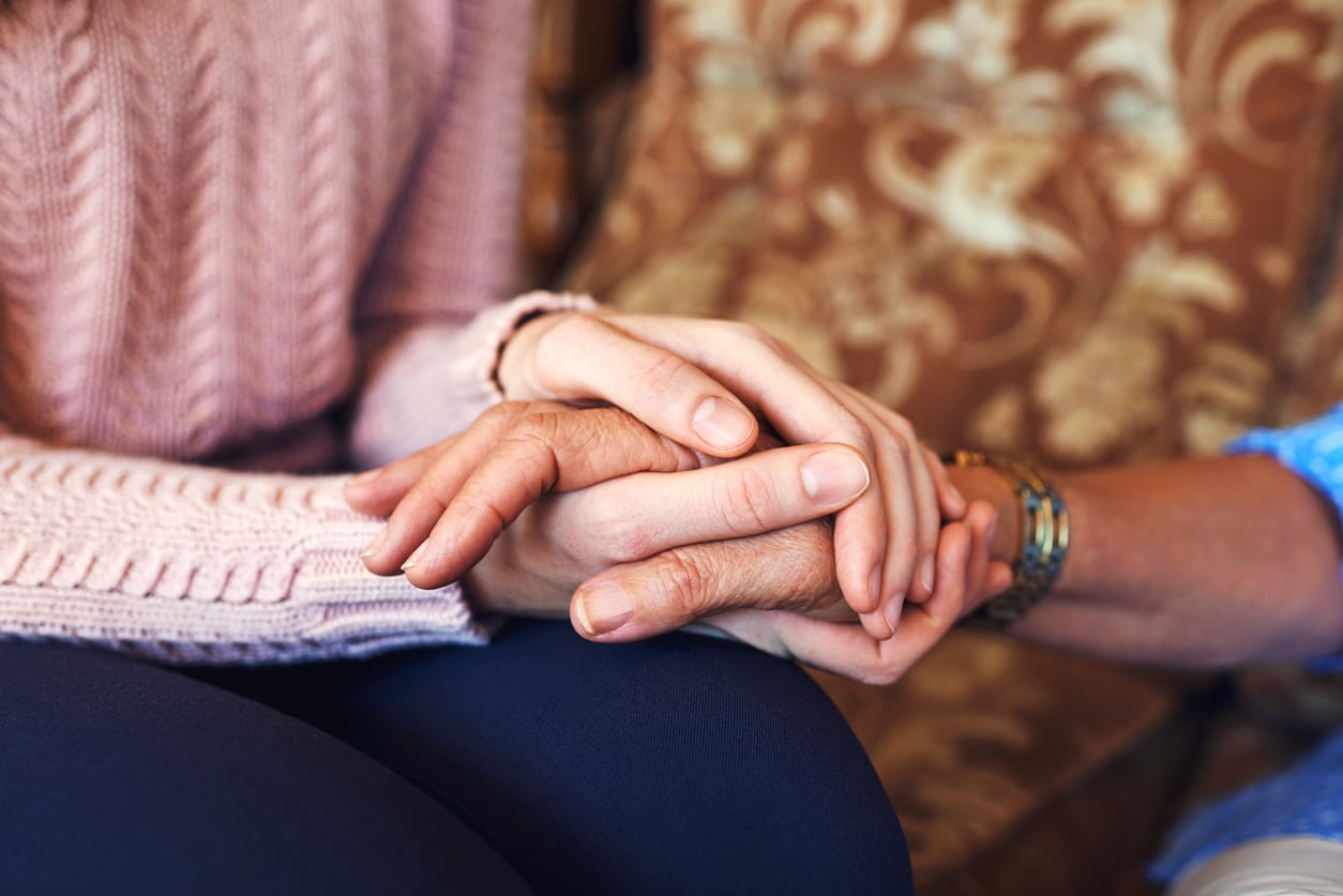 Young woman holding her old father's hand