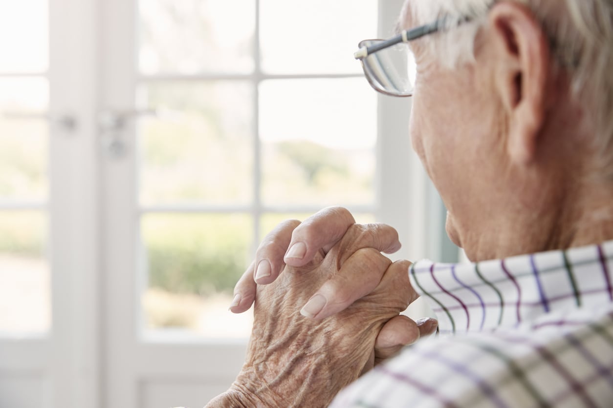 Old man gazing out a window