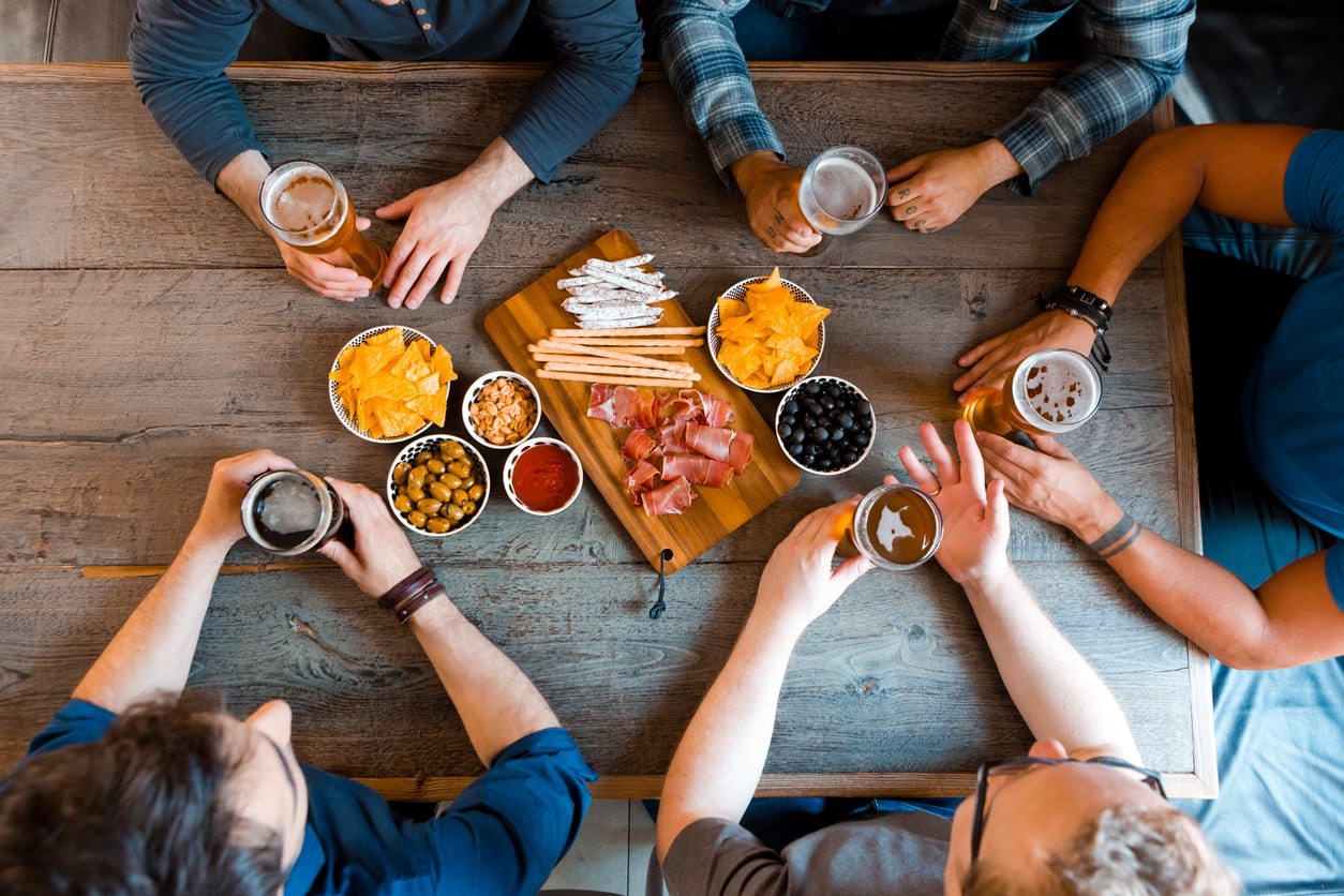 Group of friends eating and drinking at a pub