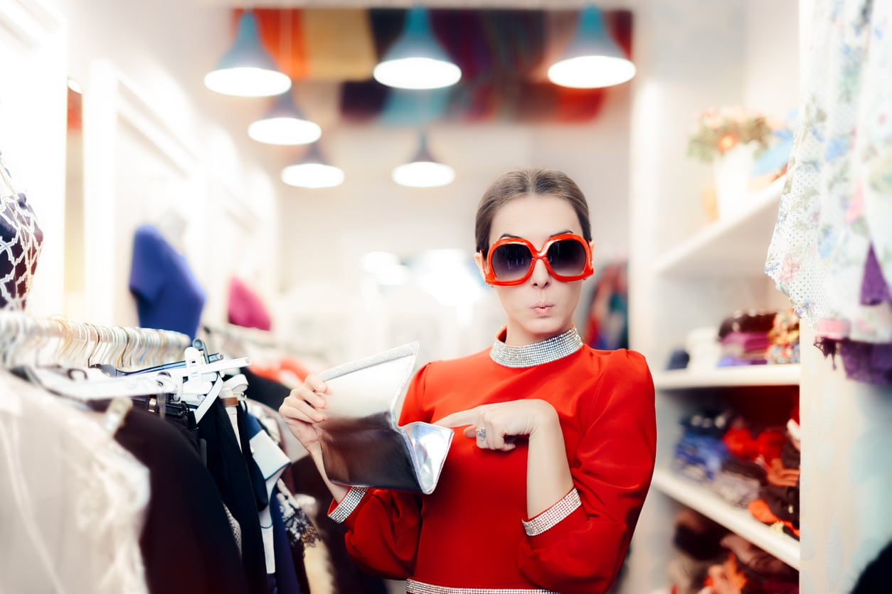 Woman wearing red dress looking at purse and shopping