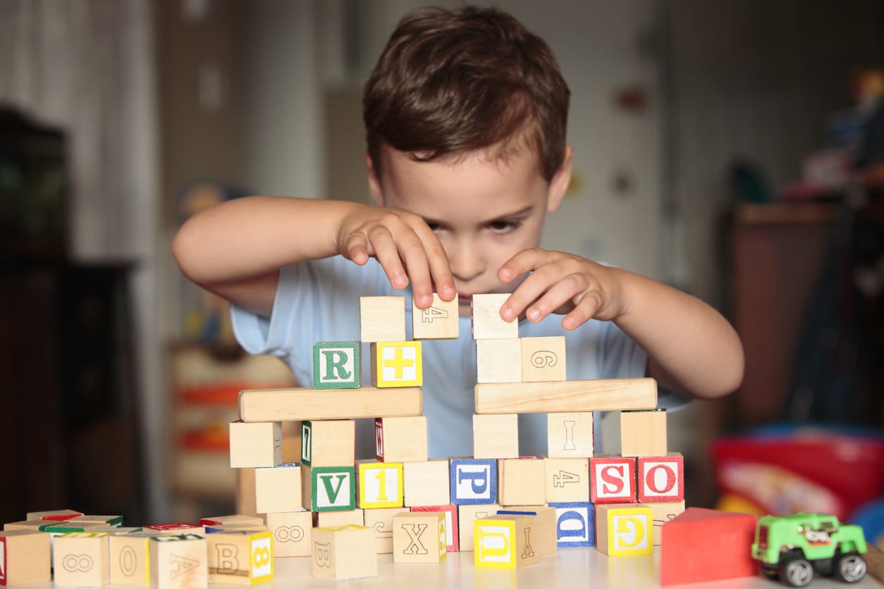 Patient child carefully stacking building blocks