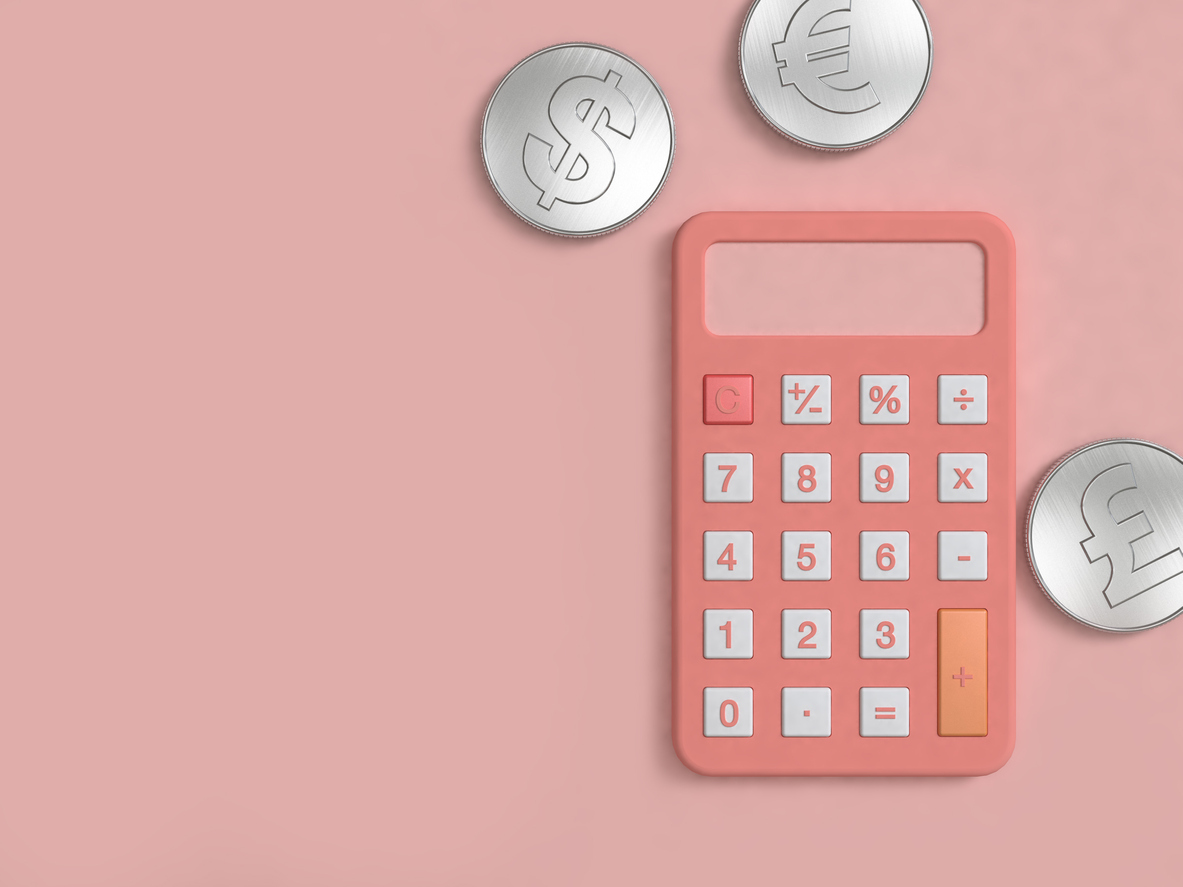 A pink calculator with coins around it
