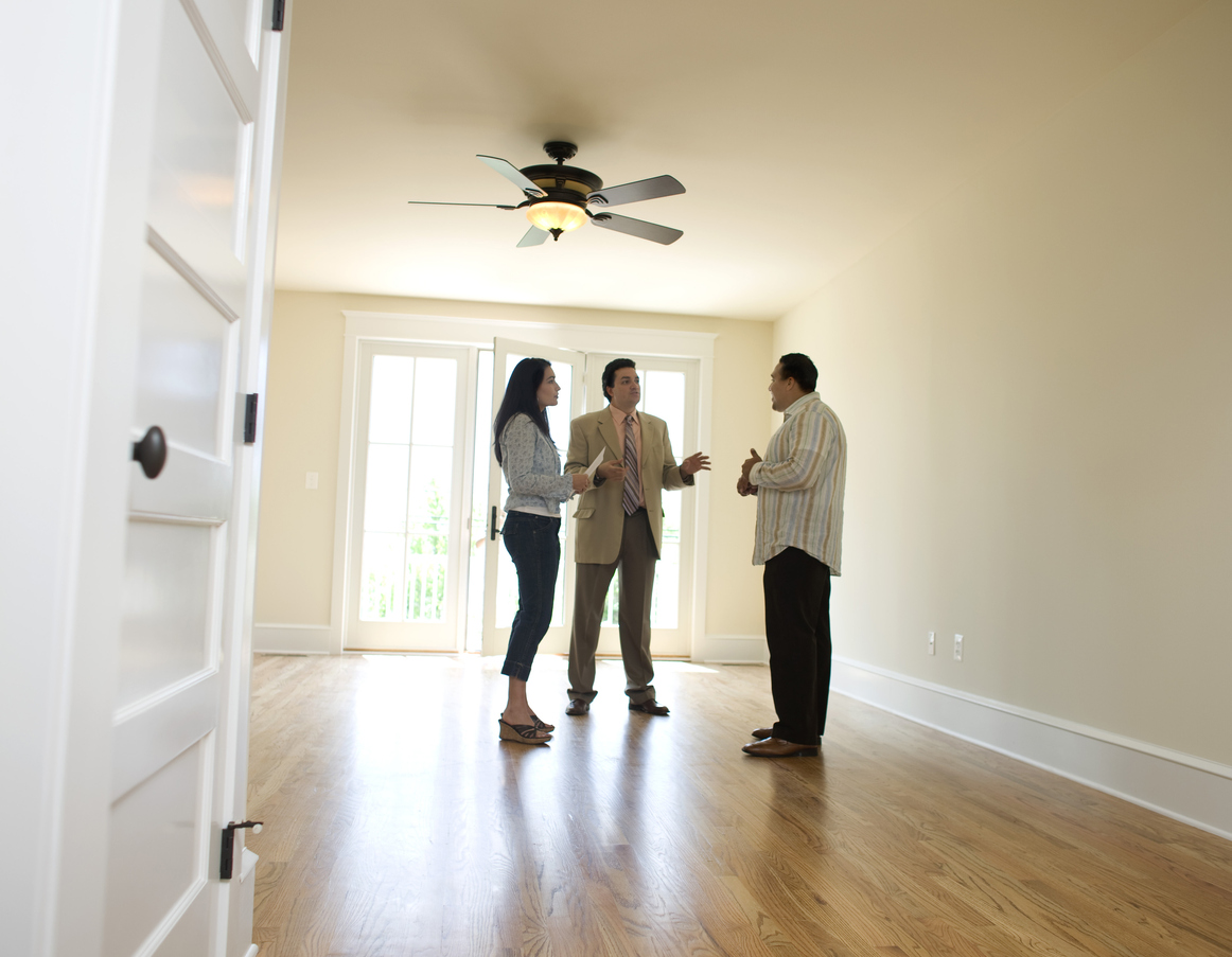 Couple in an empty home with a real estate agent