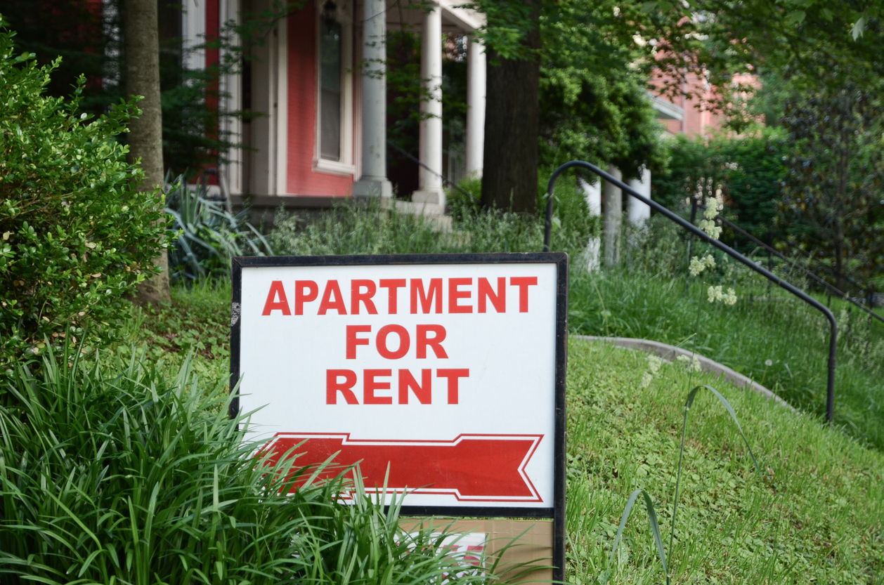 Apartment for rent sign on lawn