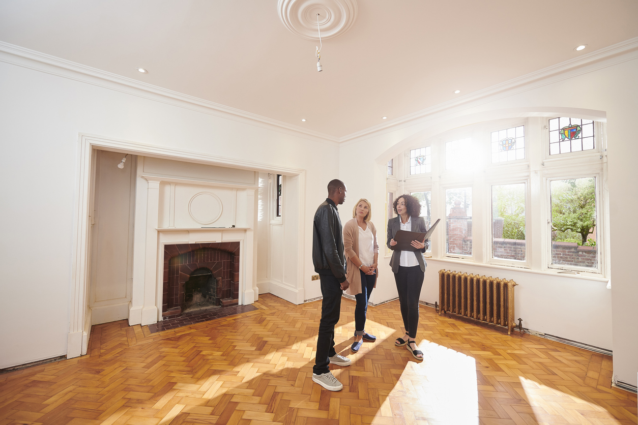 Young couple in an empty home with a real estate agent