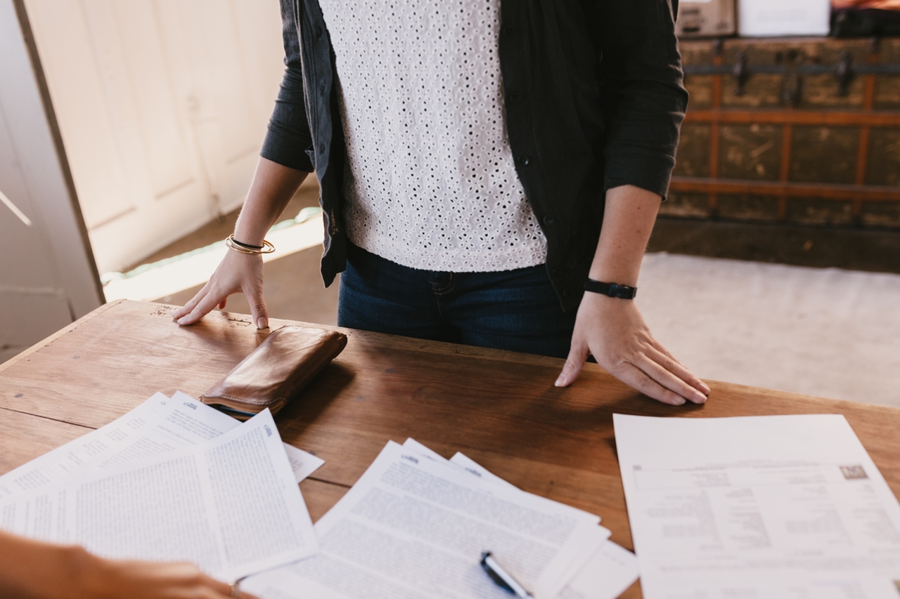 Woman looking seriously at her bills and thinking about taking action