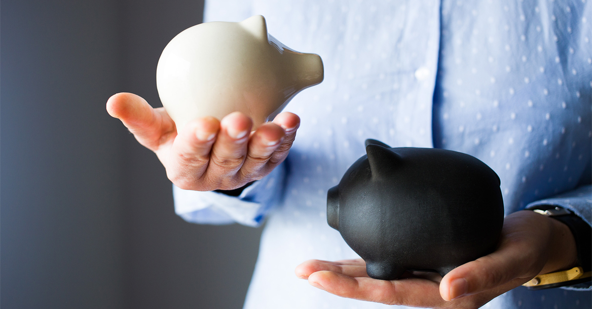 A woman holding two different piggy banks