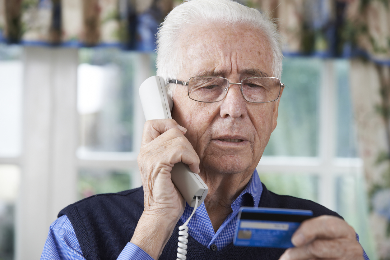 Elderly man on the phone reading his credit card details